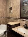 Bathroom with tile walls, vanity, and a shower with shower door