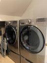 Laundry room with vaulted ceiling, tile patterned floors, and independent washer and dryer