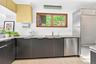 Kitchen with stainless steel appliances, light tile patterned floors, light stone countertops, and modern cabinets