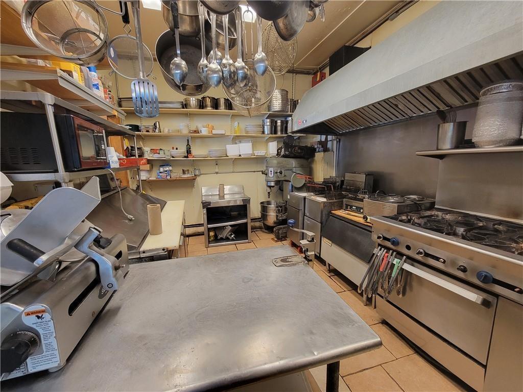 Kitchen with light tile patterned flooring, extractor fan, and open shelves