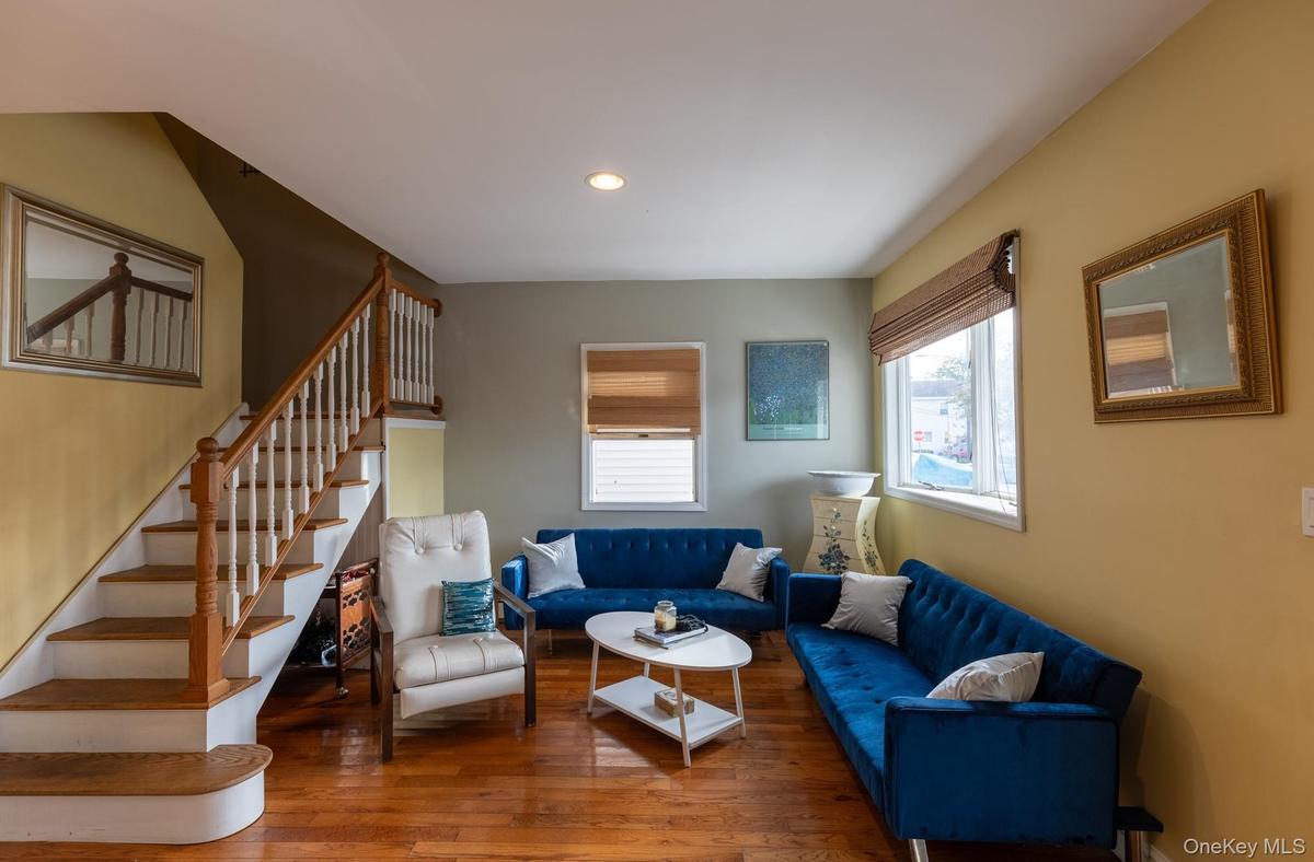 Living room featuring wood-type flooring, stairway, and recessed lighting