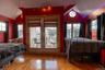 Bedroom featuring vaulted ceiling, multiple windows, hardwood / wood-style floors, and access to outside