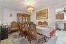 Dining space featuring light colored carpet and ceiling fan with notable chandelier