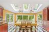 Oversized breakfast area overlooking property with cherry cabinets, skylights, and doors leading to deck