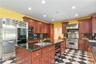 Outstanding kitchen, with custom ccherry cabinets, large island, chef’ s appliances,  granite counters and fireplace