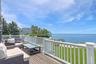 Wooden terrace featuring a water view, a lawn, and outdoor lounge area
