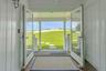 Doorway to outside with dark wood finished floors, plenty of natural light, and a water view