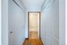 Hallway with wood finished floors, looking at the primary bathroom