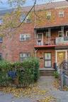 View of front of property with a balcony and brick siding