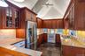 Kitchen featuring glass insert cabinets, white appliances, backsplash, and high vaulted ceiling