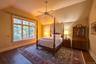 Bedroom featuring vaulted ceiling, dark wood-type flooring, and a ceiling fan