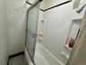 Bathroom with enclosed tub / shower combo, tile patterned floors, and tile walls