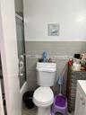 Bathroom featuring tile walls, a wainscoted wall, and shower / bath combination with glass door