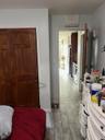 Bedroom featuring a closet, wood finish floors, and fridge
