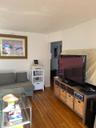Living area featuring a textured wall, a textured ceiling, and wood finished floors