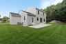 Rear view of house with a lawn, a patio, a shingled roof, and entry steps
