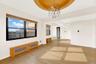 Spare room with a chandelier, light wood-type flooring, and a raised ceiling