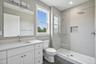 Bathroom featuring tile walls, vanity, and a shower stall