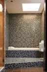 Bathroom featuring a shower stall, tile patterned flooring, tiled tub, and tile walls