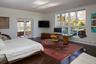 Bedroom with wood finished floors, access to exterior, a desk, and a baseboard radiator