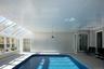 Indoor pool featuring a skylight and a sunroom