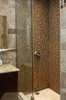 Full bath featuring tiled shower and tile walls