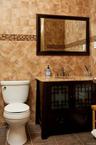 Half bath with vanity, dark tile patterned flooring, and tile walls