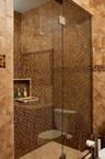 Bathroom featuring a stall shower and tile walls