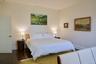 Bedroom with dark wood finished floors and baseboards