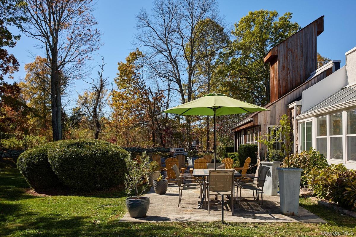View of grassy yard featuring a patio area and a sunroom