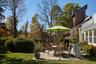 View of grassy yard featuring a patio area and a sunroom