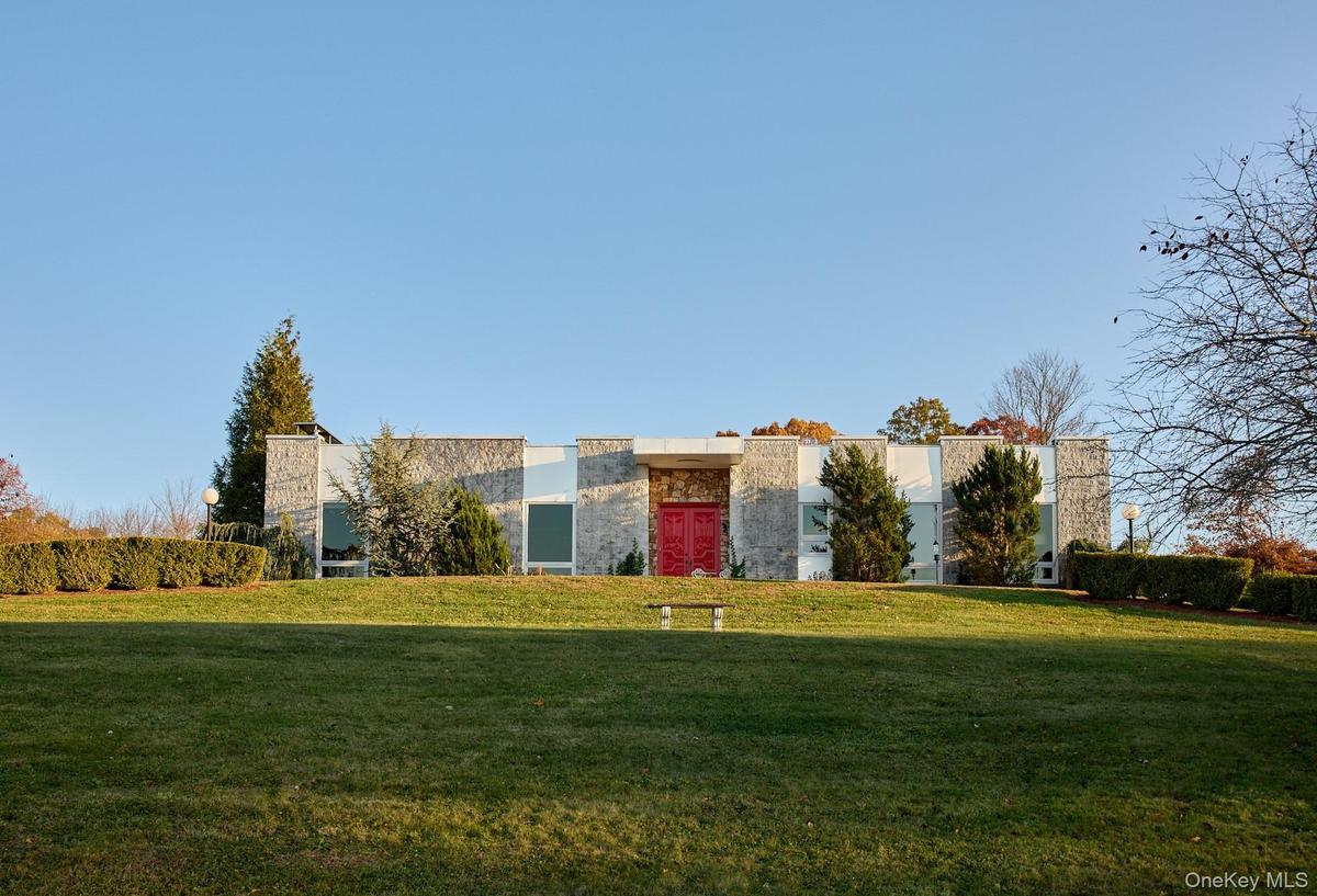 Contemporary house with a front lawn and stone siding