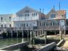 Rear view of property with a sunroom and a water view