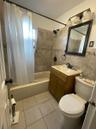 Full bath with tile walls, shower / bath combo, vanity, and tile patterned flooring