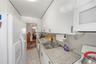 Kitchen with white appliances, backsplash, light countertops, and white cabinetry