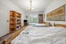 Bedroom with a chandelier, wood finished floors, and radiator
