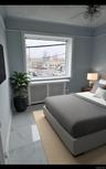 Bedroom with radiator, light marble finish flooring, multiple windows, ceiling fan, and a textured ceiling