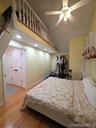 Bedroom featuring wood finished floors, a high ceiling, a ceiling fan, and recessed lighting