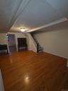 Basement featuring stairs and wood-type flooring