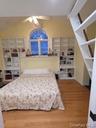 Bedroom with vaulted ceiling, light wood-style floors, and ceiling fan