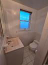 Half bath with vanity, light tile patterned floors, tile walls, and a wainscoted wall