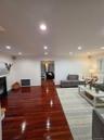 Living room with a glass covered fireplace, dark wood-type flooring, recessed lighting, and heating unit