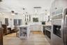 Kitchen with stainless steel appliances, a peninsula, a kitchen bar, open shelves, and glass insert cabinets