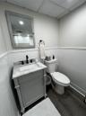 Bathroom featuring dark wood-style flooring, a shower with shower curtain, vanity, and wainscoting