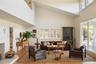Living area featuring light wood-style flooring, high vaulted ceiling, and a fireplace