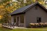 Rear view of property featuring a metal roof, log veneer siding, and a deck