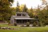 Back of property with faux log siding, a lawn, a porch, and a shingled roof