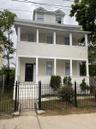 View of front facade featuring a porch, stucco siding, and a balcony