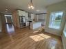 Kitchen featuring open floor plan, white cabinets, and stainless steel fridge