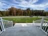 View of patio / terrace with a wooden deck and a view of trees